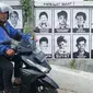 Pengendara sepeda motor melintas di depan poster 13 aktivis yang hilang di kawasan Beji, Depok, Jawa Barat, Selasa (18/6/2019). Poster tersebut mengingatkan masyarakat masih ada pekerjaan rumah pemerintah berupa pelanggaran HAM berat yang belum tuntas hingga kini. (Liputan6.com/Immanuel Antonius)