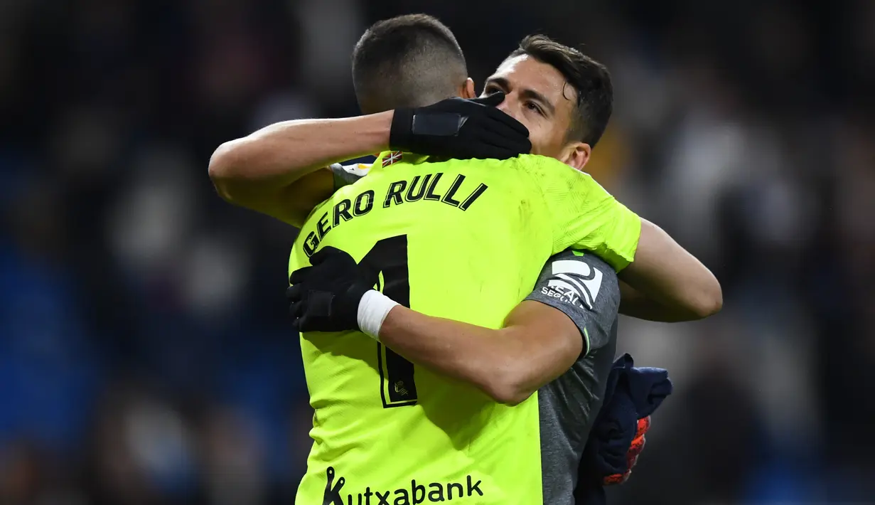 7. Kiper Sociedad, Geronimo Rulli berpelukan dengan Hector Moreno pada laga lanjutan La Liga Spanyol yang berlangsung di Stadion Santiago Bernabeu, Madrid, Senin (7/1). Real Sociedad menang 2-0 atas Real Madrid. (AFP/Gabriel Bouys)