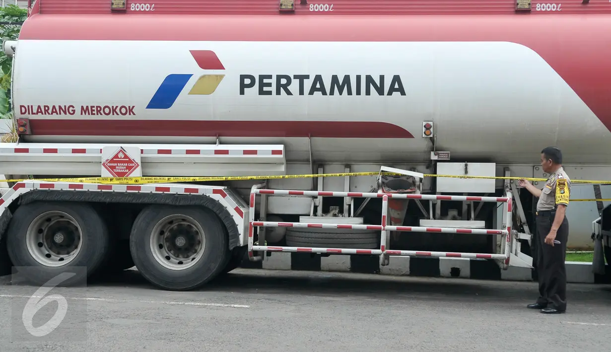 Petugas polisi memeriksa garis polisi yang terpasang di truk pengisian bahan bakar solar di SPBU Jalan Juanda, Depok, Senin (14/11). SPBU itu ditutup sementara karena salah satu pompa bahan bakar solarnya diduga bercampur air. (Liputan6.com/Yoppy Renato)