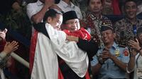Presiden RI, Joko Widodo dan Ketua Umum IPSI, Prabowo Subianto, berpelukan dengan peraih medali emas pencak silat, Hanifan Yudani di Padepokan Pencak Silat TMII, Jakarta, Rabu (29/8). ANTARA FOTO/Kumparan/INASGOC/Aditia Noviansyah/pras/18