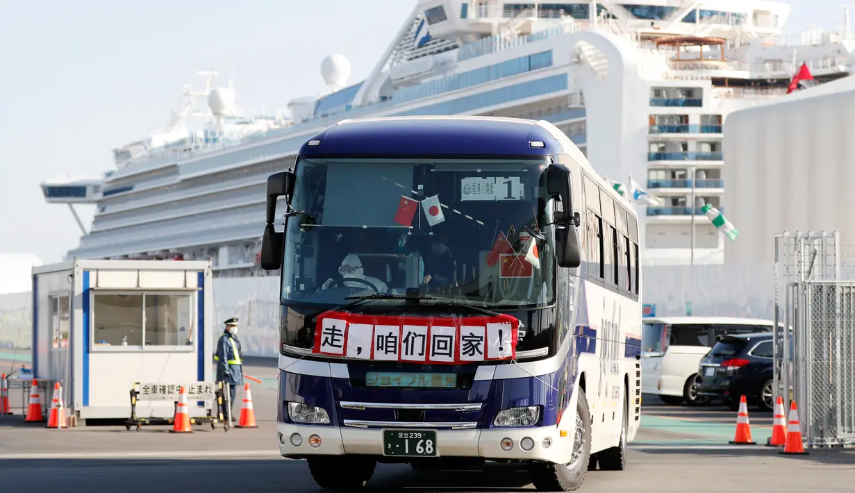 Bus dengan spanduk China bertuliskan 'Pergi, Kita Pulang!' membawa penumpang Hong Kong dari kapal pesiar Diamond Princess yang dikarantina di Yokohama, Jepang, Jumat (21/2/2020). Ratusan orang yang dinyatakan negatif virus corona (COVID-19) berangsur meninggalkan kapal. (AP Photo/Eugene Hoshiko)