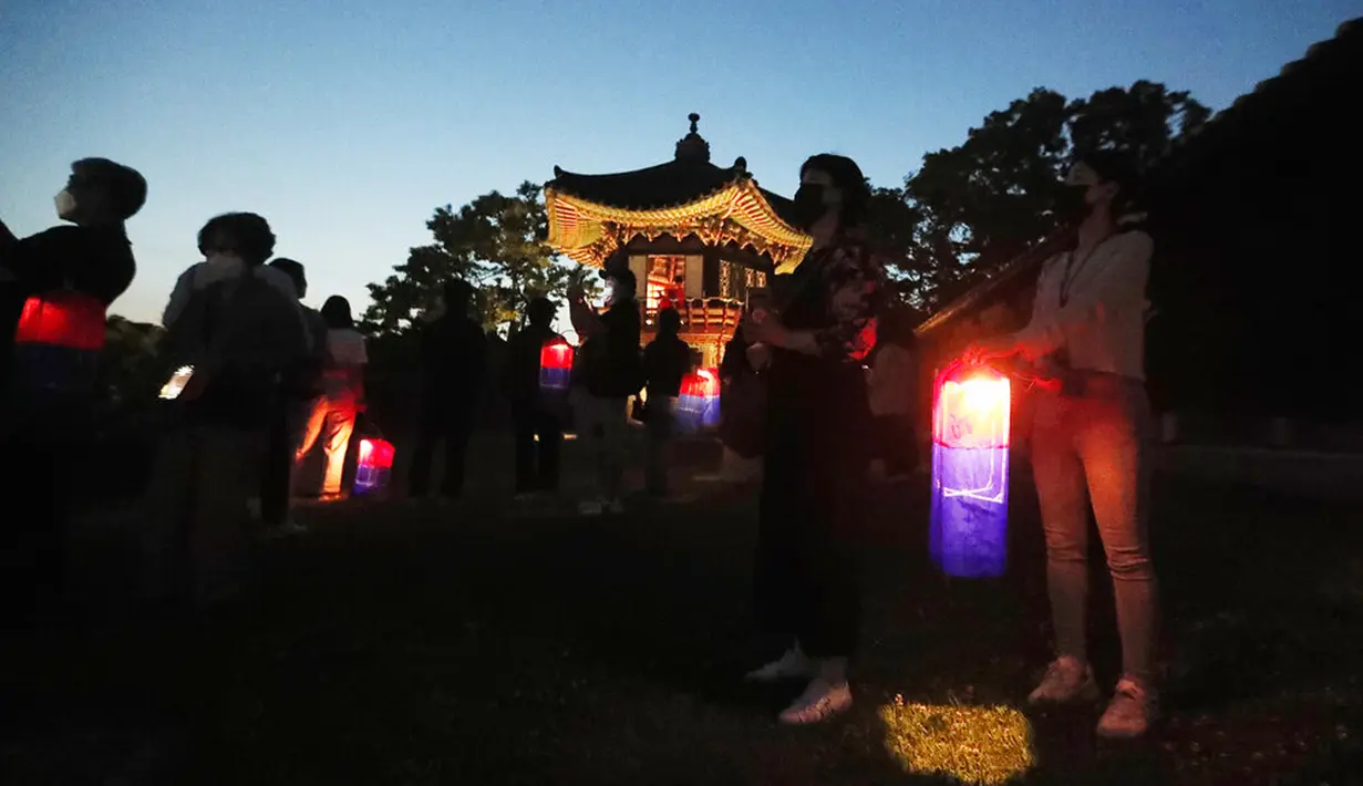Pengunjung yang memegang lentera tradisional Korea menghadiri Tur Cahaya Bulan di tengah pandemi virus corona COVID-19 di Istana Changdeokgung, Seoul, Korea Selatan, Kamis (13/5/2021). Istana Changdeok adalah istana Dinasti Joseon. (AP Photo/Ahn Young-joon)