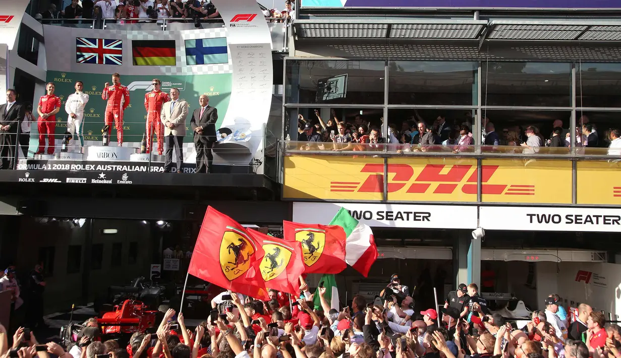 Sebastian Vettel berada di atas podium merayakan kemenangan bersama fans pada balapan pertama musim ini di Grand Prix Formula Satu Australia di Melbourne, (25/3). Vettel memenangi balapan dengan selisih 5,036 detik dari Hamilton. (AP Photo / Rick Rycroft)