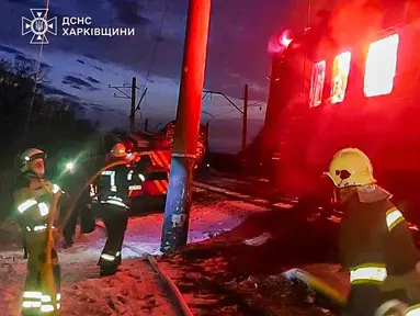 Dalam foto yang dirilis oleh Layanan Darurat Ukraina pada 27 Januari 2026 ini, para penyelamat Ukraina berupaya memadamkan api di gerbong kereta api setelah serangan udara di lokasi yang tidak diungkapkan di wilayah Kharkiv, di tengah invasi Rusia ke Ukraina. Serangan pesawat nirawak (drone) Rusia menghantam sebuah kereta penumpang sipil di wilayah Kharkiv, Ukraina. (Handout/UKRAINIAN EMERGENCY SERVICE/AFP)
