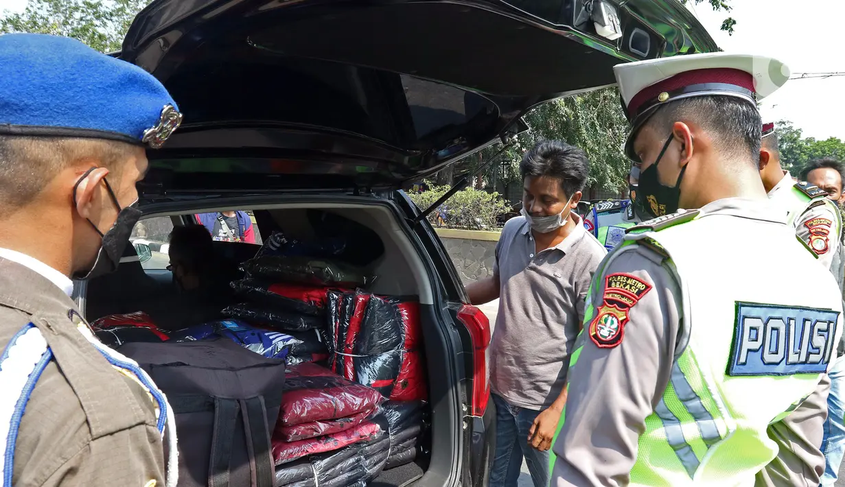 Polisi mengecek bawaan kendaraan yang melintas di Kedungwaringin, Kabupaten Bekasi, Kamis  (29/4/2021). Satlantas Polres Metro Bekasi memeriksa kesehatan dengan swab antigen dan sosialisasi larangan mudik jelang lebaran di perbatasan Kabupaten Bekasi dan Karawang. (Liputan6.com/Herman Zakharia)