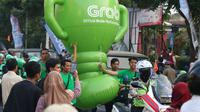Mitra dari Grab membawa balon raksasa saat obor Asian Games XVIII melintas di Kota Malang, Jawa Timur, Jumat (20/7/2018). Sebanyak 53 kota di Indonesia akan dilalui oleh obor Asian Games. (Bola.com/Aditya Wani)