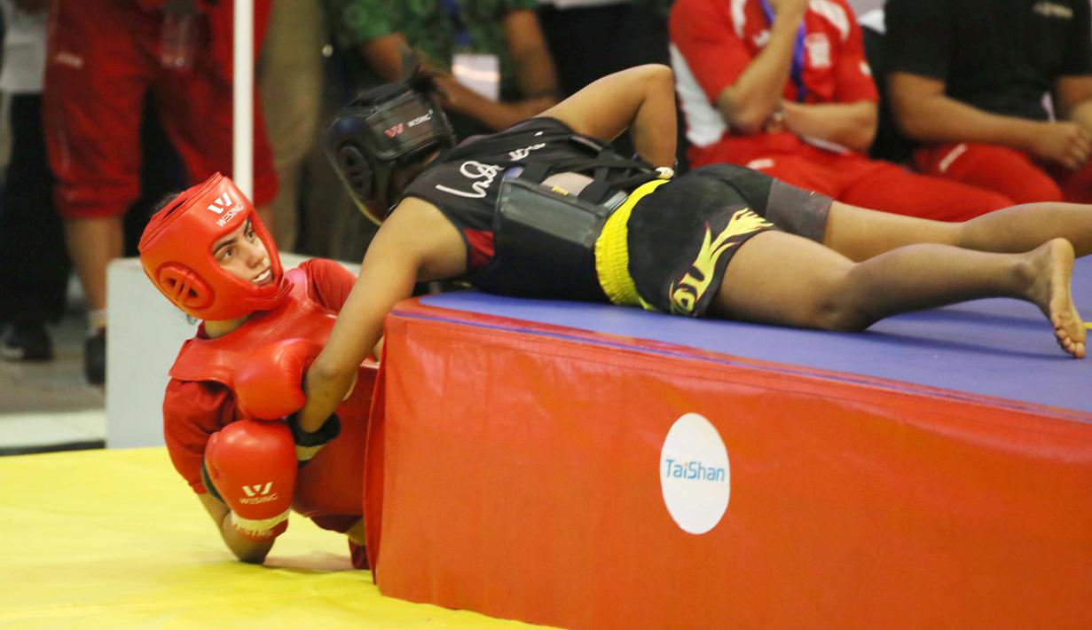 Atlet wushu Indonesia, Moria Manalu (kanan), membanting lawannya asal Turki, Nagihan Kalyoncu, di kelas Sanda Wanita 60 kg pada Kejuaraan Dunia Wushu 2015 di Istora Gelora Bung Karno, Senayan, Jakarta, Senin (16/11/2015). (Bola.com/Nicklas Hanoatubun)