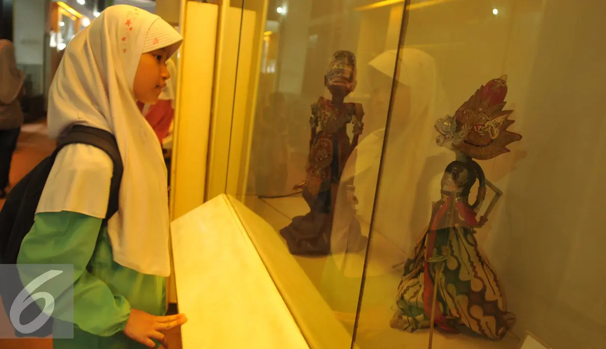 Pengunjung mengamati koleksi Museum Wayang di Kota Tua, Jakarta, Jumat (8/7). Selama liburan lebaran, pengunjung Museum Wayang meningkat hingga empat kali lipat dari hari biasa. (Liputan6.com/Gempur M Surya)