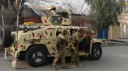 Tentara Afghanistan bersiap siaga di dekat sebuah kantor amal Inggris Save the Children saat terjadi serangan yang sedang berlangsung di Jalalabad, Afghanistan (24/1). Serangan tersebut sedikitnya melukai 11 orang. (AFP Photo/Noorullah Shirzada)