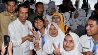 Presiden Joko Widodo berfoto bersama sejumlah siswa saat acara penyerahan KIP dan PKH di Kota Banjarbaru, Kalimantan Selatan (26/3). (Liputan6.com/Pool/Biro Setpres)