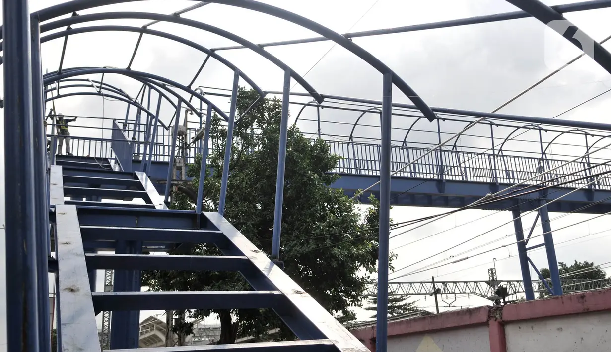 Pekerja menyelesaikan pembangunan jembatan penyeberangan orang (JPO) di dekat Stasiun Jatinegara, Jakarta, Senin (11/5/2020). JPO yang ditargetkan rampung pada tahun ini tersebut sekaligus menjadi jalur keluar penumpang kereta Stasiun Jatinegara. (merdeka.com/Iqbal S. Nugroho)