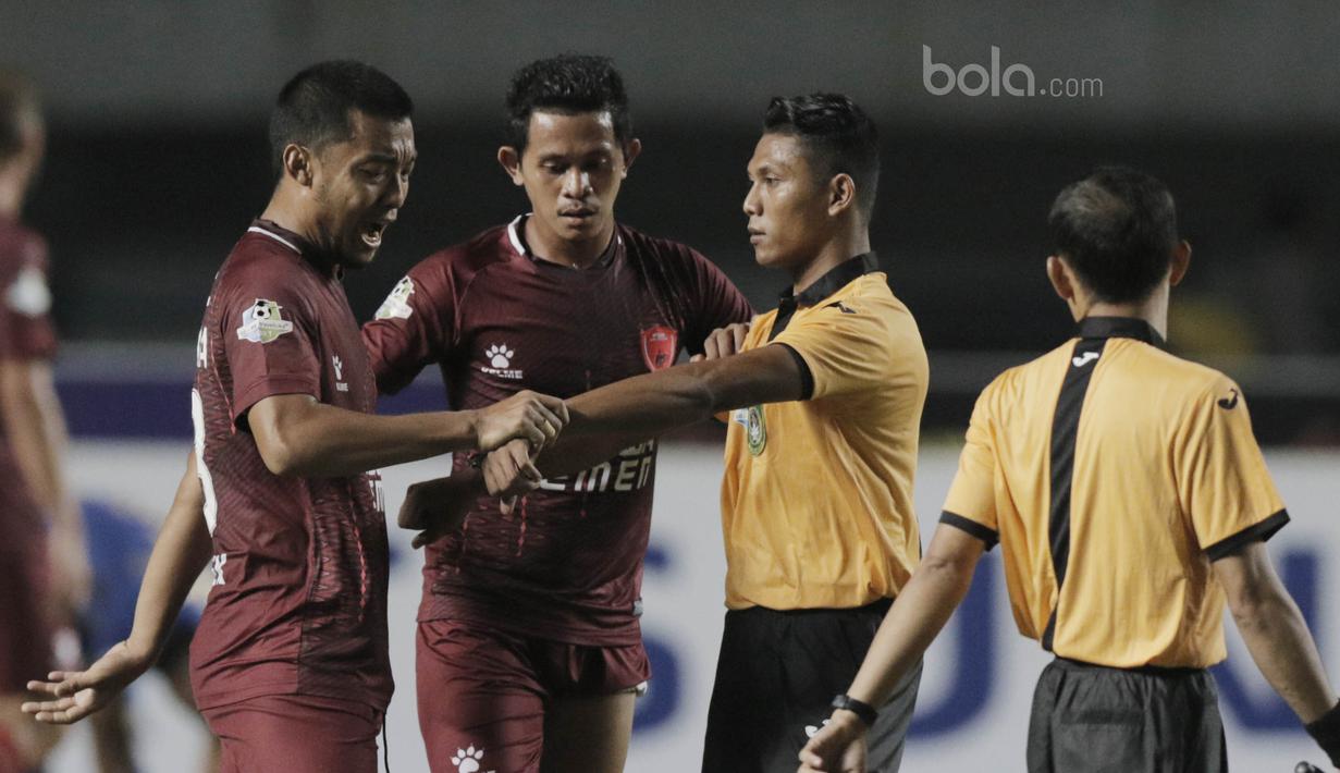 Kapten PSM Makassar, Hamkah Hamzah, memprotes keputusan wasit terkait waktu pertandingan saat laga melawan Persib Bandung dalam lanjutan Liga 1 di Stadion GBLA, Bandung, Rabu, (5/7/2017). (Bola.com/M Iqbal Ichsan)
