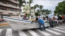 Para nelayan mendorong perahu mereka yang biasanya berlabuh di Teluk Meksiko, menuju pinggir jalan di pelabuhan kota Veracruz, Rabu (9/8). Meksiko bersiap menghadapi kedatangan Franklin, yang berubah menjadi badai dengan Kategori 1. (Victoria RAZO/AFP)