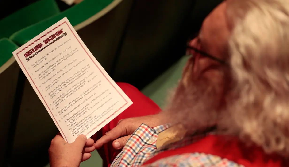 Seorang siswa sekolah Santa Claus Charles W. Howard mendapat pelajaran bagaimana menjadi Santa yang sukses di Midland, Michigan, Jumat (19/10). Sekolah ini khusus mengajarkan para lansia yang ingin menjadi sinterklas. (JEFF KOWALSKY / AFP)