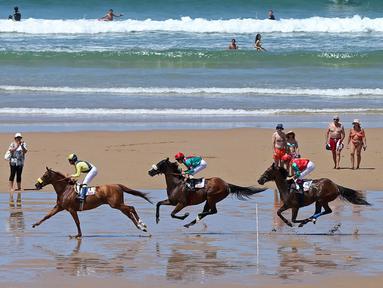Para joki beraksi dalam kejuaraan tahunan pacuan kuda pantai di Loredo, Santander, Spanyol, (24/7/2016). (AFP/Cesar Manso)
