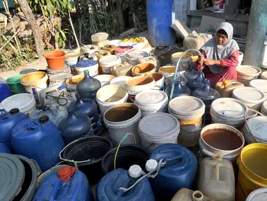 Seorang ibu mengisi air pada antrean jeriken di sumur Masjid  di Kampung Citapen, Desa  Weninggalih, Bogor, Rabu (24/07/2019). Sekitar 4000 jiwa warga Desa Weninggalih mengalami kesulitan mendapatkan air bersih akibat musim kemarau sejak tiga bulan terakhir. (merdeka.com/Arie Basuki)