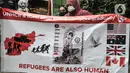 Pencari suaka asal Afghanistan membentangkan poster tuntutan di depan Kantor UNHCR, Jakarta, Senin (15/11/2021).  Ratusan pencari suaka tersebut menuntut segera dipindahkan ke negara ketiga yang terbebas dari konflik perang setelah lebih 10 tahun mengungsi di Indonesia. (merdeka.com/Iqbal S Nugroho)