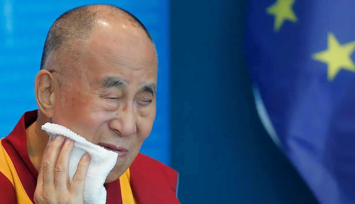 Dalai Lama mengelap wajahnya saat pidato di Dewan Eropa di Strasbourg, Perancis, Kamis (15/9). Ini adalah kunjungan Eropa pertama Dalai Lama setelah lima tahun. (REUTERS / Vincent Kessler)