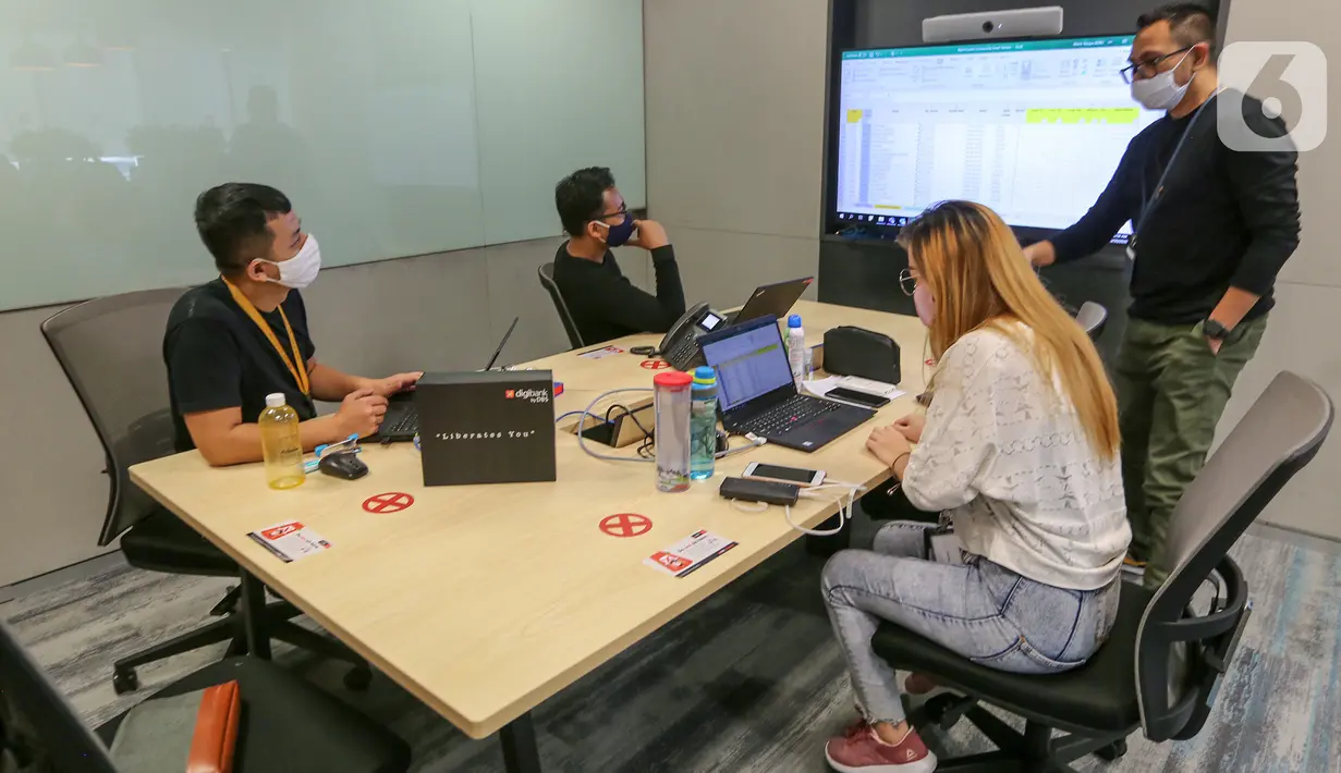 Sejumlah karyawan sedang rapat mengikuti aturan physical distancing di kantor DBS Tower, Jakarta, Selasa (30/6/2020). Bank DBS Indonesia menerapkan protokol kesehatan, penyesuaian operasional dan penataan ulang struktur penempatan karyawan di area kantor. (Liputan6.com/Fery Pradolo)