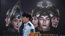 Seorang petugas berjalan melewati poster film Asura di stasiun kereta bawah tanah di Beijing, Selasa (17/7). Selain kurangnya penonton, film ini juga menerima ulasan yang mengerikan pada saat dirilis. (AFP/GREG BAKER)