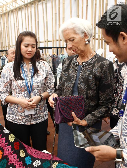 Managing Director IMF Christine Lagarde memegang tas yang dipamerkan saat berkunjung ke Paviliun Indonesia di arena pertemuan IMF-Bank Dunia, Bali, Rabu (10/10). (Liputan6.com/Angga Yuniar)