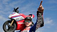 Pembalap MotoGP Scott Redding berpose dengan motor listrik mini saat acara jumpa pers jelang MotoGP Jepang di sirkuit Twin Ring Motegi, Jepang (12/10). (AP Photo / Shizuo Kambayashi)