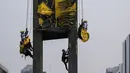 Seorang personel militer Indonesia memanjat Patung Selamat Datang untuk menurunkan aktivis Greenpeace Indonesia yang melakukan aksi protes di kawasan Bundaran Hotel Indonesia, Jakarta, Selasa (20/10/2026). Aksi tersebut digelar bertepatan dengan dua tahun pelantikan Presiden Prabowo Subianto. Para aktivis mendesak pemerintah mengambil langkah nyata untuk mengatasi krisis iklim yang kian memburuk serta kenaikan biaya hidup. (BAY ISMOYO/AFP)