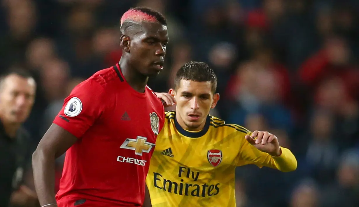 Pemain Manchester United Paul Pogba (kiri) berebut bola dengan pemain Arsenal Lucas Torreira dalam lanjutan Liga Inggris di Old Trafford, Manchester, Inggris, Senin (30/9/2019). Pertandingan berakhir 1-1. (AP Photo/Dave Thompson)