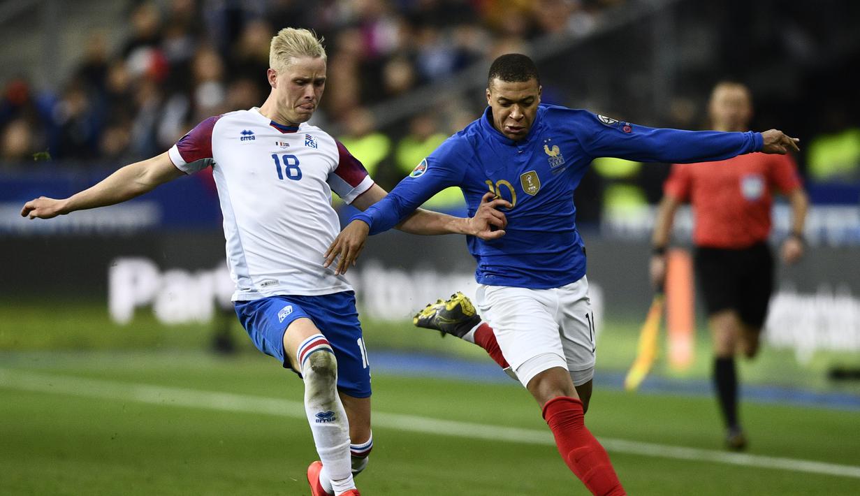 Kylian Mbappe mencoba melewati Hordur Magnusson pada laga kedua Kualifikasi Piala Eropa 2020 Grup H yang berlangsung di Stadion Stade de France, Paris, Selasa (26/3). Perancis menang 4-0 atas Islandia. (AFP/Martin Bureau)