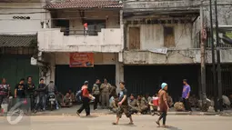 Warga melintas di depan toko yang ada di Jalan Jatinegara Barat,  Jakarta, Jumat (21/8/2015). Penutupan terkait proses penggusuran warga yang tinggal di sekitar bantaran Kali Ciliwung di Kampung Pulo Jakarta Timur. (Liputan6.com/Helmi Fithriansyah)