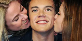 Penggemar wanita One Direction berpose mencium patung lilin dari salah satu bintang One Direction, Harry Styles, di Madame Tussauds di London, Inggris (18/4/2013). (Bintang/EPA)