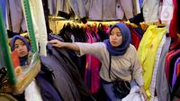 Seorang calon pembeli memilih pakaian impor bekas di Pasar Senen, Jakarta, Kamis (9/3/2023). Larangan impor baju bekas bertujuan untuk mendukung penggunaan produk lokal dan usaha kecil dan menengah milik masyarakat Indonesia. (Liputan6.com/Faizal Fanani)