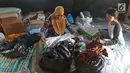 Korban kebakaran memilih bantuan berupa pakaian di posko pengungsian SDN 10/11 Pagi Cipinang Utara, Jakarta, Selasa (20/8/2019). Puluhan warga terdampak kebakaran di Kawasan Prumpung, Jatinegara saat ini masih sangat membutuhkan bantuan seperti alas tidur dan popok bayi. (Liputan6.com/Herman Zakhari