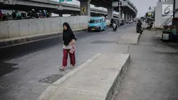 Pejalan kaki melintas di samping trotoar yang berada di tengah jalan di kawasan Kalimalang, Senin (16/9/2019). Selain dikeluhkan pengendara karena membahayakan, keberadaan trotoar tak lazim itu dinilai mempersempit jalan dan kerap menimbulkan macet saat jam sibuk. (Liputan6.com/Faizal Fanani)