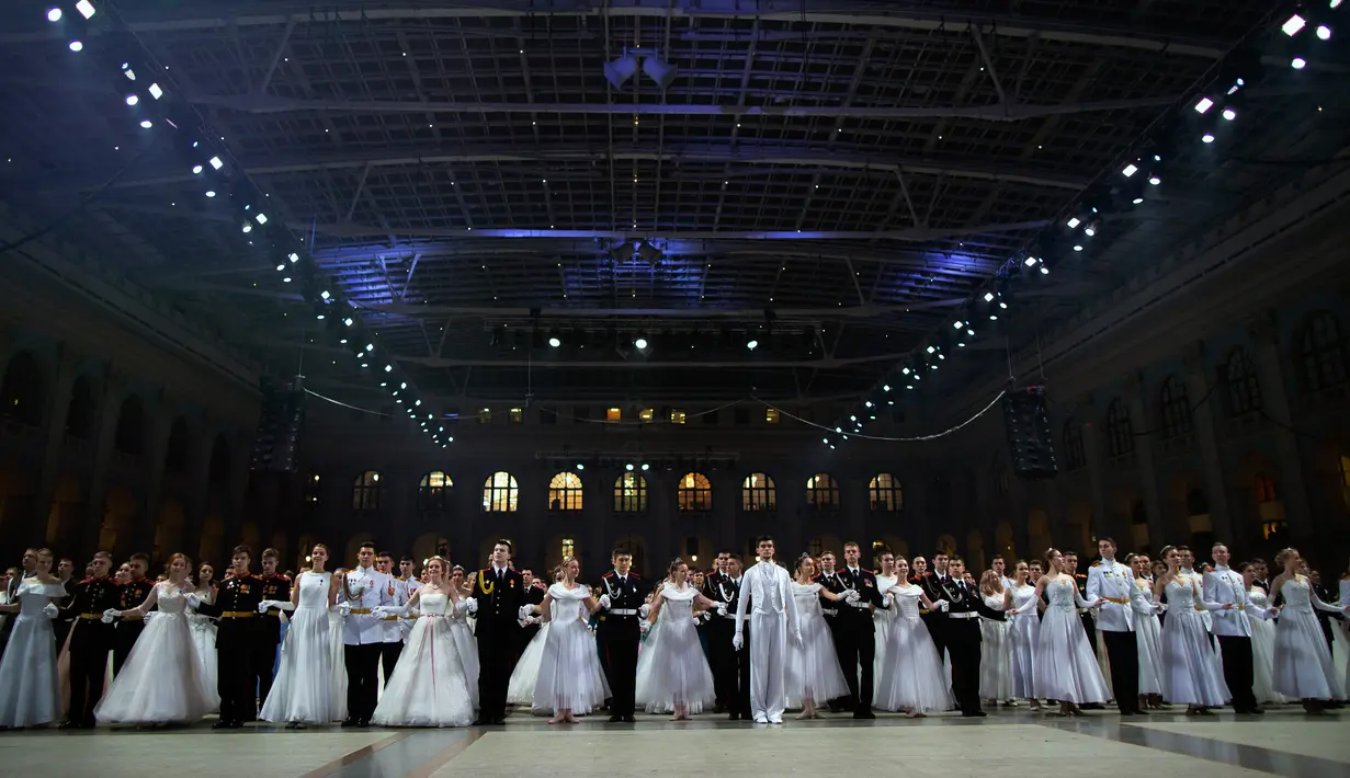 Para siswa sekolah militer bersiap untuk menari saat pesta tahunan Cadet Ball di Moskow, Rusia, Selasa (17/12/2019). Dalam acara ini para peserta mengenakan seragam dan gaun sambil menari tradisional dengan alunan musik klasik. (AP Photo/Alexander Zemlianichenko)