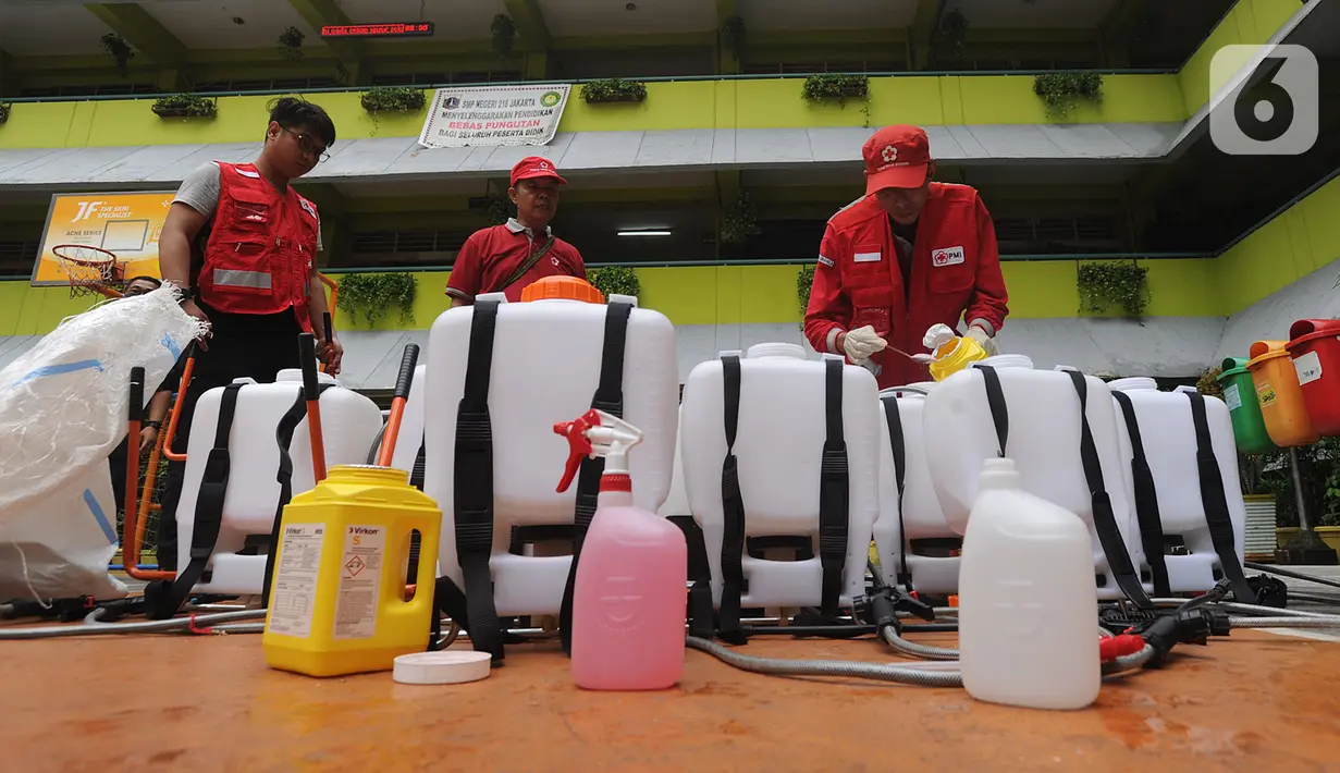 Petugas Palang Merah Indonesia (PMI) bersiap melakukan penyemprotan disinfektan di SMPN 216 Jakarta, Senin (16/3/2020). Mulai hari ini, aktivitas sekolah di sejumlah wilayah Indonesia diliburkan untuk mengantisipasi penyebaran virus corona COVID-19. (merdeka.com/Arie Basuki)