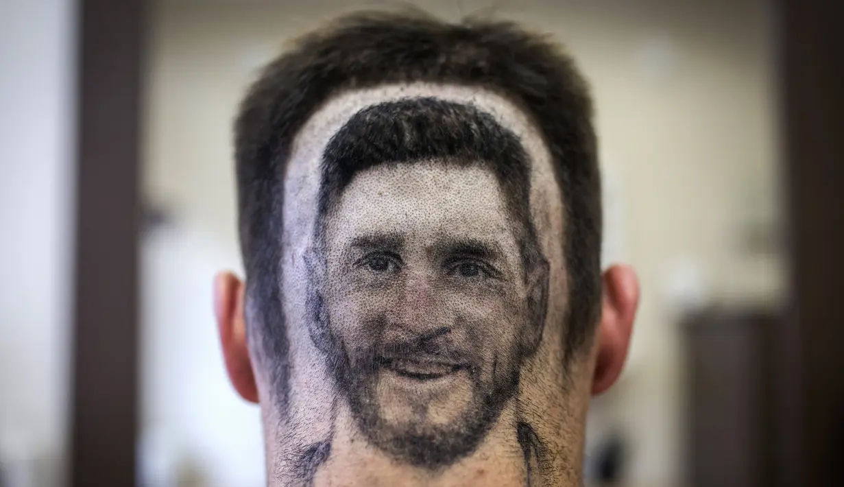 Seorang penggemar menunjukkan tato rambut wajah Lionel Messi di sebuah salon rambut di Serbia, 10 Juni 2018. Sang penata rambut memberi masukan kepada pelanggannya untuk melakukan sesuatu yang berbeda jelang Piala Dunia 2018. (AFP/VLADIMIR ZIVOJINOVIC)