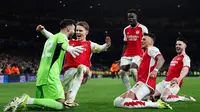 Para pemain Arsenal menghampiri sang penjaga gawang, David Raya, yang sukses menggagalkan dua eksekutor penalti Porto dalam laga 16 besar Liga Champions 2023/2024 di Emirates Stadium, Rabu (13/3/2024) dini hari WIB. Arsenal yang menang 1-0 dalam laga tersebut, harus menyelesaikan laga lewat drama adu penalti karena agregat imbang 1-1. The Gunners pun lolos ke perempat final setelah menang 4-2 pada babak tos-tosan itu. (Adrian DENNIS / AFP)