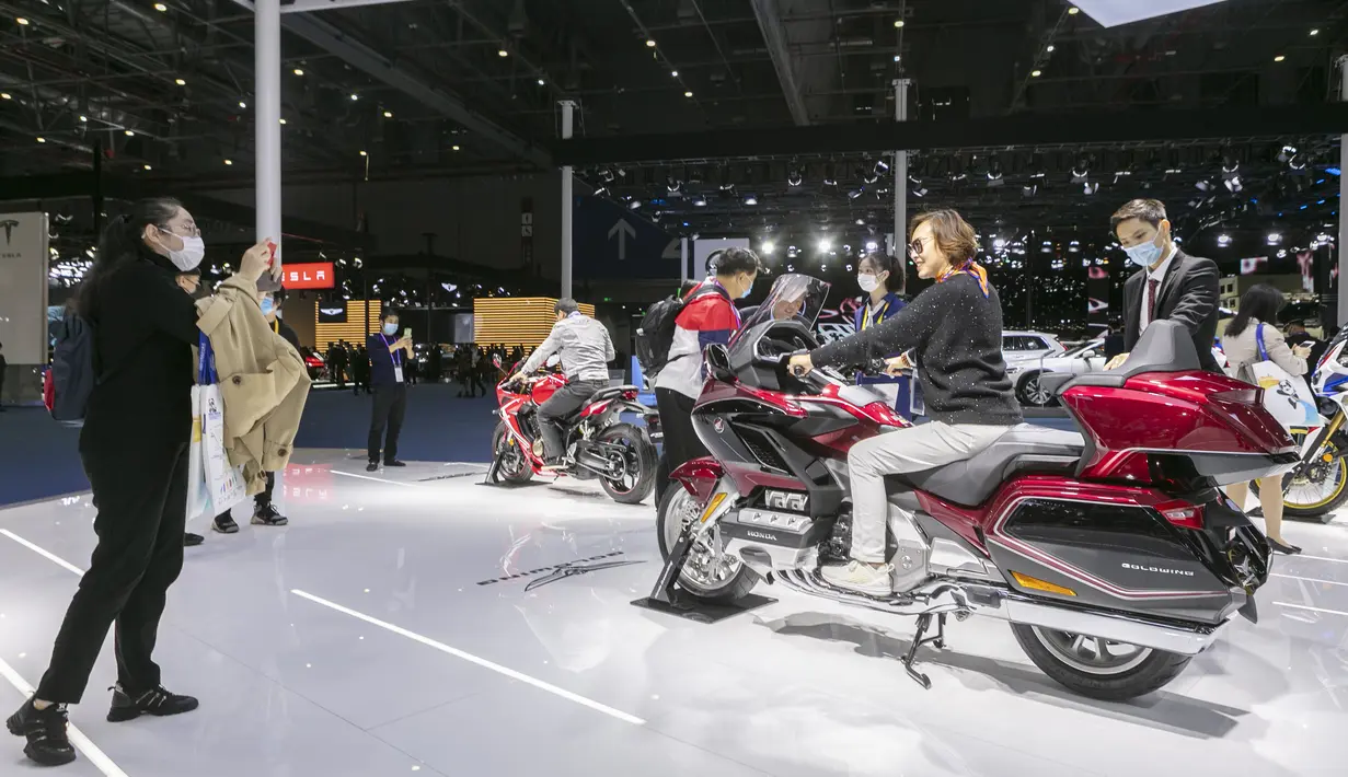 Orang-orang menjajal sepeda motor Honda dalam Pameran Impor Internasional China (China International Import Expo/CIIE) ketiga di Shanghai, China timur (5/11/2020). Total tujuh pabrikan otomotif top dunia berpartisipasi dalam ajang CIIE tahun ini. (Xinhua/Zhao Dingzhe)