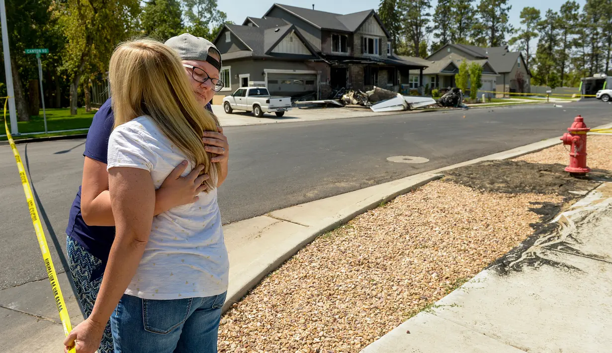Pejabat Federal Aviation Administration menyelidiki lokasi pesawat yang sengaja menabrak rumah di Payson, Utah, Senin (13/8). Menurut polisi, tindakan pria yang tewas dalam aksinya itu untuk membunuh sang istri. (Scott G Winterton/The Deseret News via AP)