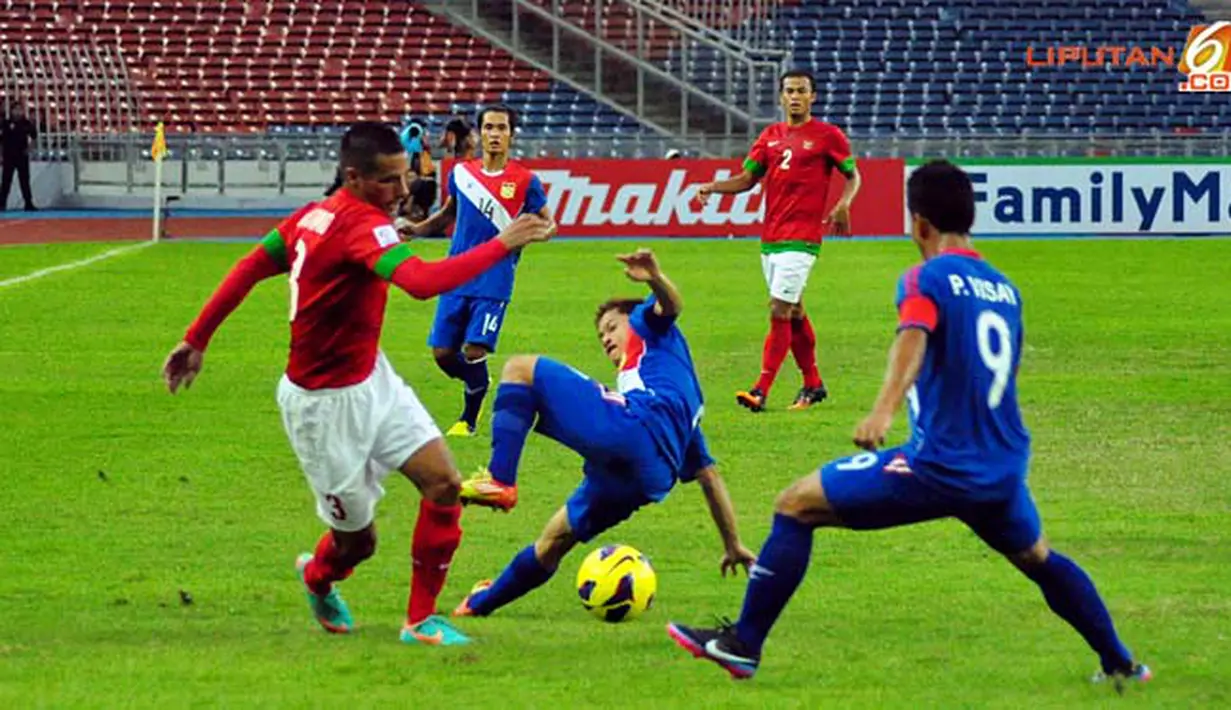 Pemain Timnas Indonesia Raphael Maitimo berusah keluar dari jagaan pemain Timnas Laos dalam Laga Piala AFF Suzuki 2012 Minggu 25 November 2012, di Stadion Bukit Jalil, Kuala Lumpur Malaysia. Pertandingan berakhir dengan Skor 2-2.