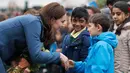 The Duchess of Cambridge, Kate Middleton menyalami anak-anak saat berkunjung ke Roe Green Junior School di London, Selasa, (23/1). (AP Photo/Frank Augstein)