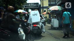 Petugas membawa logistik kotak suara Pilkada Depok 2020 untuk didistribusikan di sejumlah RW Kecamatan Beji, Depok, Selasa (8/12/2020). Total, ada 4.049 kotak suara yang sedang didistribusikan ke TPS setempat dan di dalamnya terdapat 1.262.051 lembar surat suara. (Liputan6.com/Immanuel Antonius)