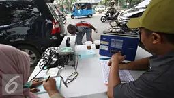 Petugas mendata kendaraan saat uji emisi di kawasan Rawamangun, Jakarta, Selasa (26/4). Kegiatan tersebut diadakan untuk mengukur kualitas udara perkotaan serta mengontrol gas buang kendaraan agar tetap layak jalan. (Liputan6.com/Immanuel Antonius)