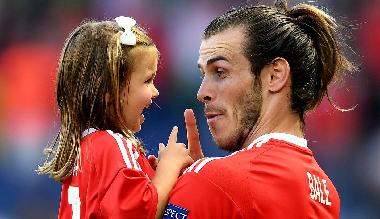 Gareth Bale terlihat memberi peringatan sambil bercanda dengan putrinya usai laga melawan Irlandia Utara pada Piala Eropa 2016 di Parc des Princes, Paris, (25/6/2016). Wales Menang 1-0. (EPA/Georgi Licovski)