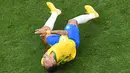 Penyerang timnas Brasil, Neymar berguling di atas lapangan pada babak 16 besar Piala Dunia 2018 melawan Meksiko di Samara Arena, Senin (2/7). Neymar dituding melakukan aksi drama yang kelewatan saat berpura-pura kesakitan.  (AFP/Kirill KUDRYAVTSEV)