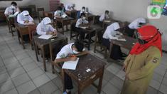 Guru mengajar para murid saat pelaksanaan uji coba pendidikan tatap muka (PTM) di SMPN 15, Kota Bogor, Jawa Barat, Senin (31/5/2021). Pemerintah Kota Bogor menggelar uji coba PTM di 37 sekolah hari ini dengan protokol kesehatan yang ketat. (merdeka.com/Arie Basuki)
