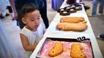 Seorang anak melihat pameran kue bulan dalam perayaan Festival Pertengahan Musim Gugur di Museum Hainan di Haikou, ibu kota Provinsi Hainan, 1 Oktober 2020. Masyarakat di seluruh China menikmati beragam makanan lezat selama libur Hari Nasional dan Festival Pertengahan Musim Gugur. (Xinhua/Guo Cheng)