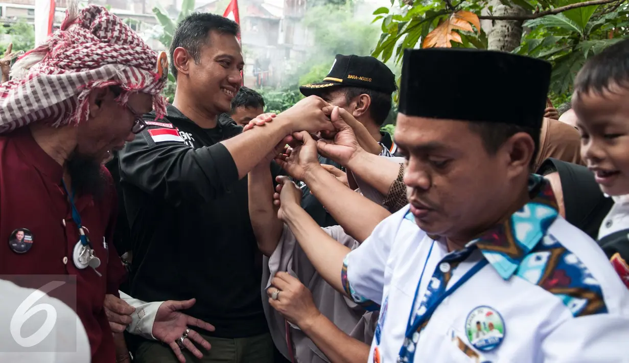 Sejumlah warga berebut hendak bersalaman dengan Calon Gubernur DKI Jakarta, Agus Harimurti Yudhoyono di Kampung Bidaracina, Jakarta, Rabu (30/1). Agus menggelar kampanye tatap muka dengan para warga di wilayah tersebut. (Liputan6.com/Gempur M Surya)