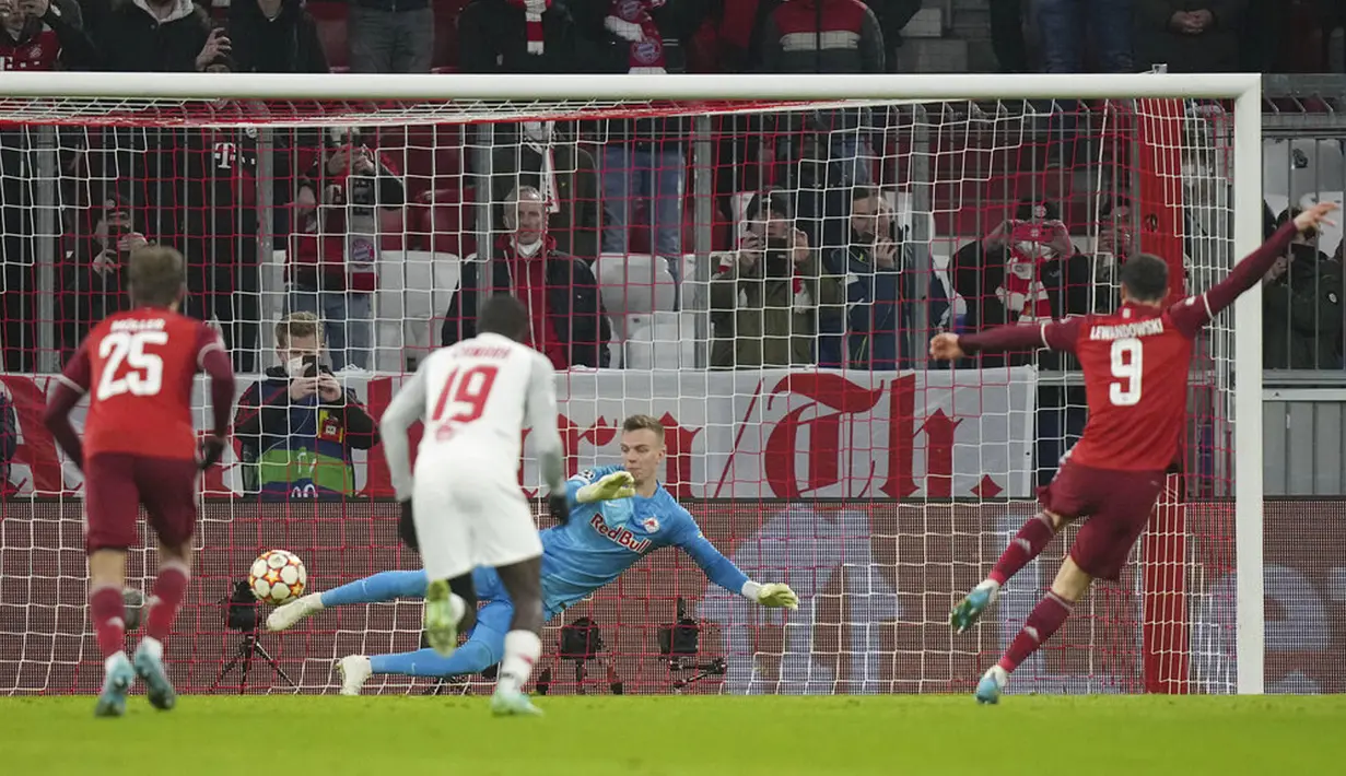Pemain Bayern Munchen Robert Lewandowski (kanan) mencetak gol lewat titik penalti ke gawang Salzburg yang dijaga Philipp Koehn pada pertandingan leg kedua babak 16 besar Liga Champions di Munich, Jerman, 8 Maret 2022. Bayern Munchen menang 7-1. (AP Photo/Matthias Schrader)